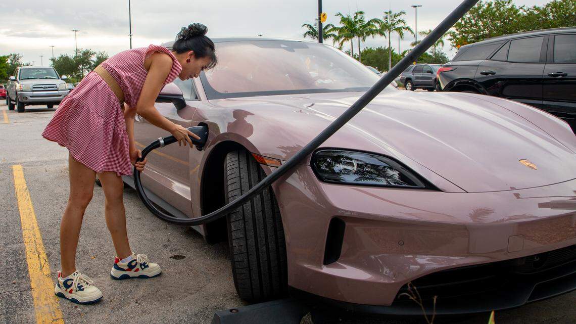 Tang P. plugs her pink Porsche Taycan into an electric vehicle charging port in the Walmart parking lot in Hialeah on Friday, Sep. 24. Tang had two cars ahead of her in line waiting to use one of the five pumps.