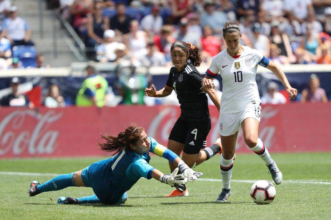 United States forward Carli Lloyd, right, dribbles past Mexico goalkeeper Cecilia Santiago to score a goal during the second half of an international friendly soccer match, Sunday, May 26, 2019, in Harrison, N.J. The U.S. won 3-0.