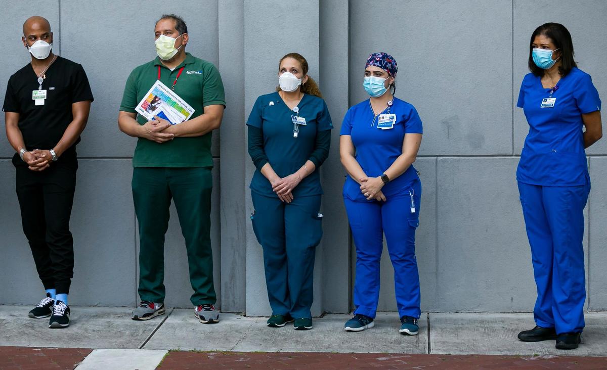 From left: Dr. Hansel Tookes, Environmental Service Worker Armando Acosta, Respiratory Therapist Elizabeth Plasencia, COVID unit nurse Yaimara Cruz and ICU Nurse Grace Meatley attend a press conference outside of Jackson Memorial Hospital in Miami, Florida, on Tuesday, December 15, 2020. The conference was held after Jackson Memorial Hospital administered the Pfizer BioNTech COVID-19 vaccine to its healthcare workers.