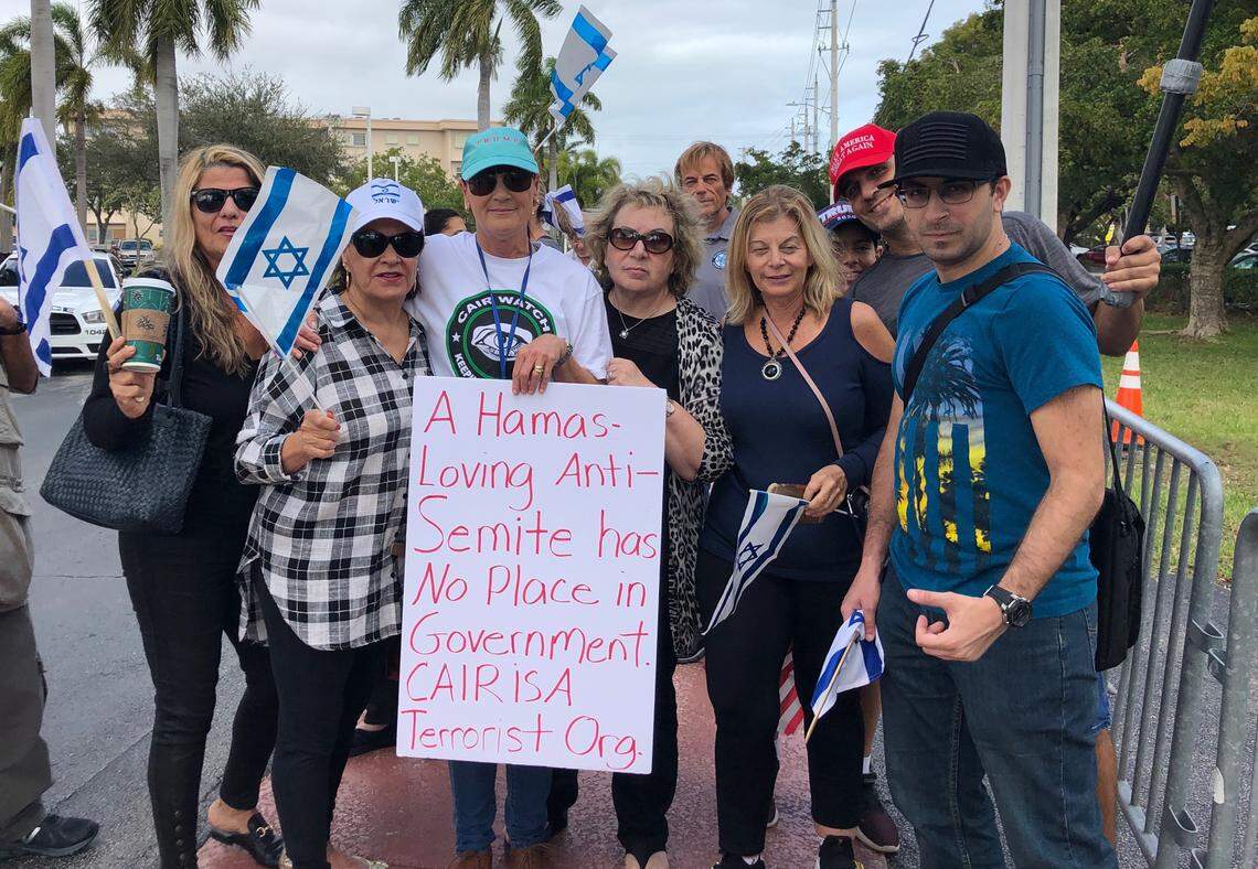Janet Komburg holds a sign, posing with the group that was first to arrive to support Hallandale Beach Commissioner Anabelle Lima-Taub on Jan. 23.