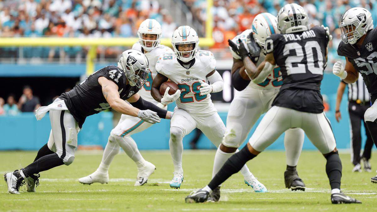 Miami Dolphins running back De’Von Achane (28) on a carry in the second half as Las Vegas Raiders linebacker Robert Spillane (41) attempts to make the stop during their NFL game in Miami Gardens, Florida on Sunday, November 17, 2024.