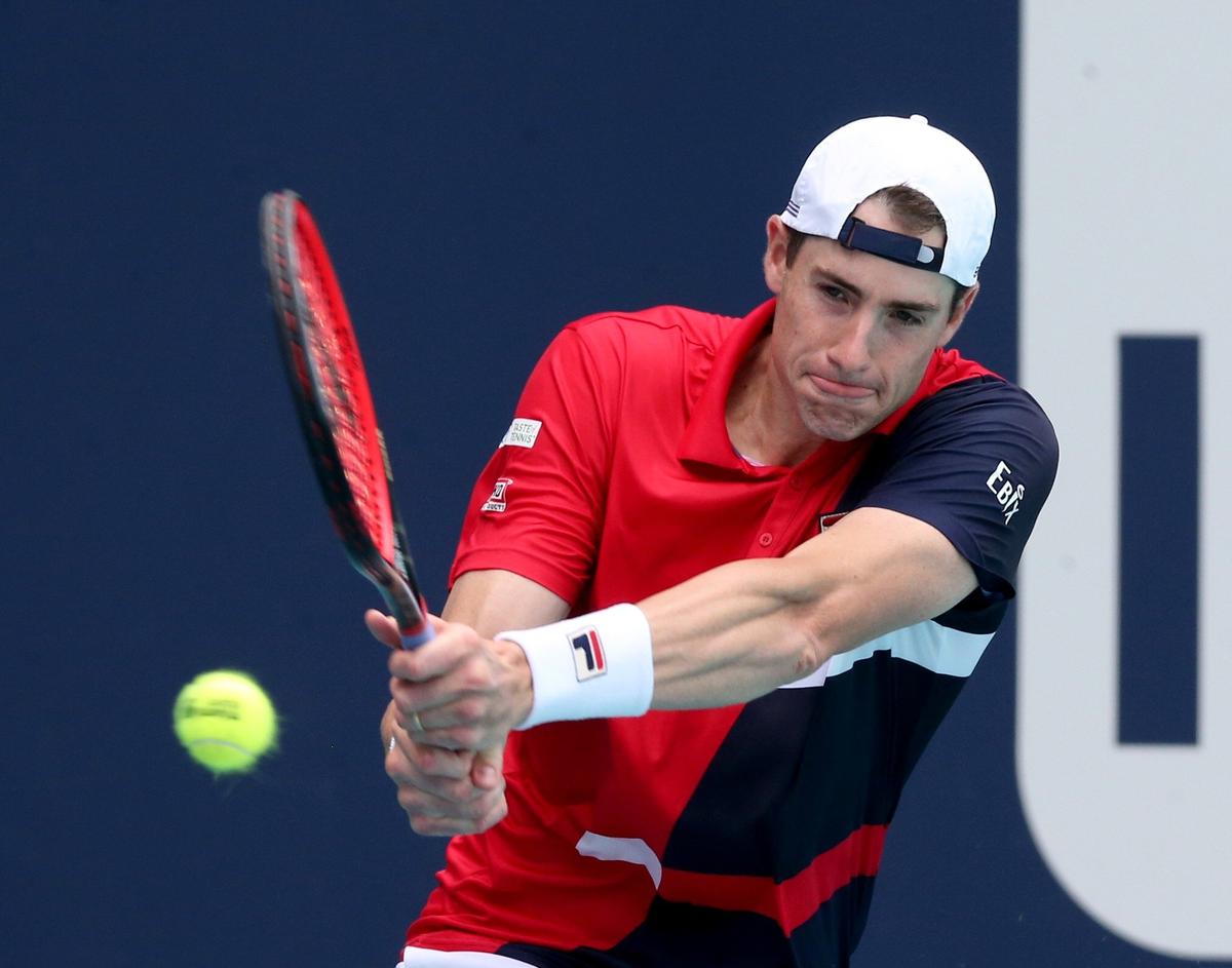 John Isner returns a ball hit by Albert Ramos-Vinolas at the 2019 Miami Open in Miami Gardens, Florida, Sunday, March, 24, 2019.