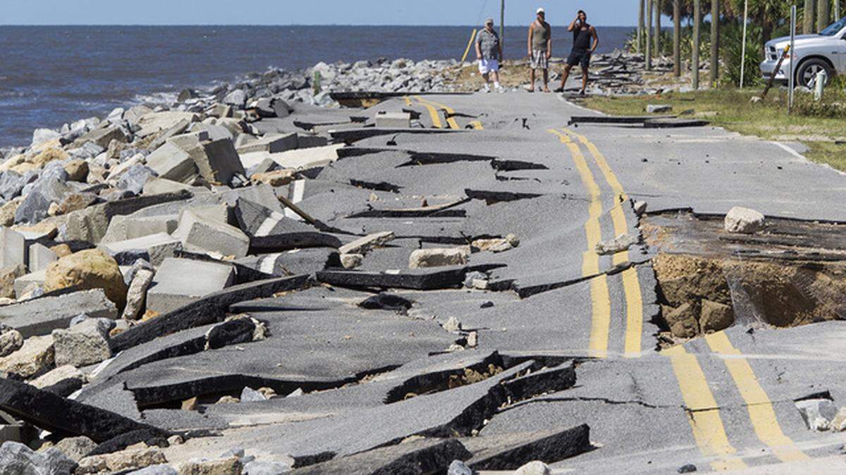 Residents look at road in Alligator Point, Florida, that collapsed during the storm surge from Hurricane Hermine in 2016.