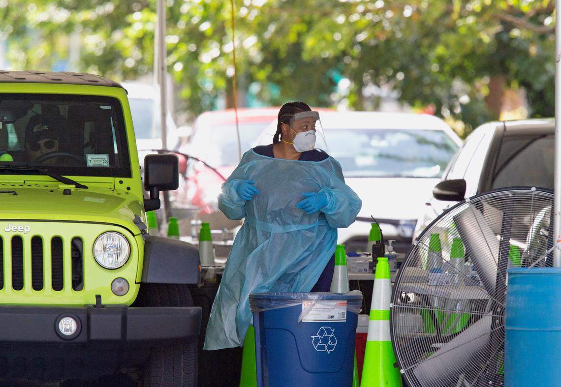 A healthcare worker collects a COVID-19 test sample after a person used a nasal swab for a self-administered test&nbsp;at the COVID-19 drive-thru testing center at the Miami Beach Convention Center on Wednesday, Nov. 18, 2020, in Miami Beach.