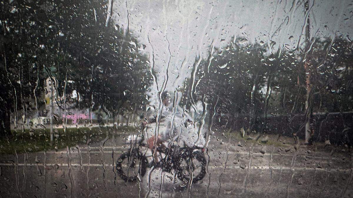 Heavy rain drenches Miami's Little Haiti on as a cyclist battled the downpour, with raindrops cascading down a car's passenger windows, highlighting the challenging weather conditions Saturday, August 23, 2025.
