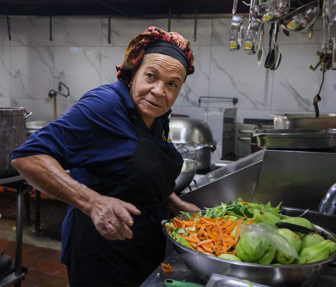 Clair Tony peels vegetables in the kitchen as staff prepares meals at Naomi's Garden in Little Haiti, Thursday, Jan. 15, 2026, in Miami, Florida.