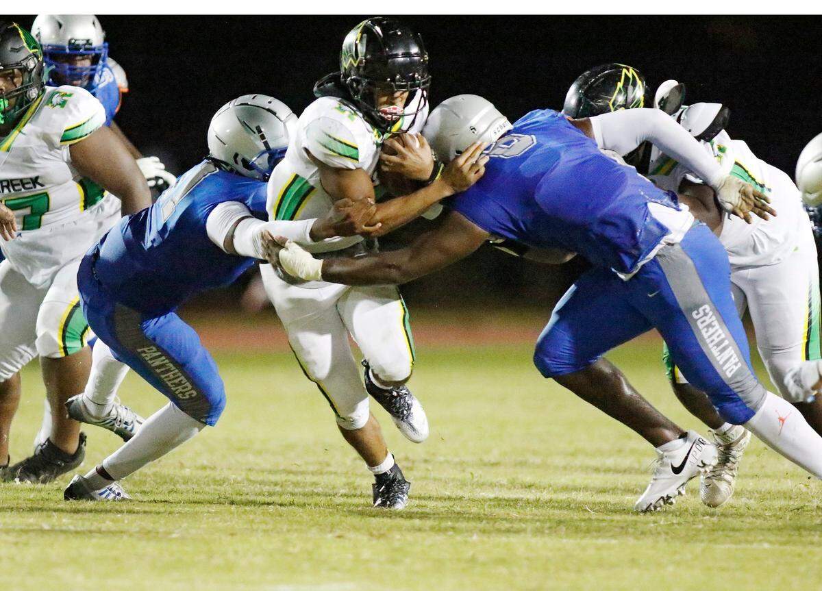 Dillard Panthers linebacker Alexis Thompson (11, left)) and defensive end Armondo Blount (8, right) tackle Rock Creek Christian Academy ball carrier during football game on Friday, August 26, 2022 at Dillard High School in Fort Lauderdale. Andrew Uloza / for Miami Herald