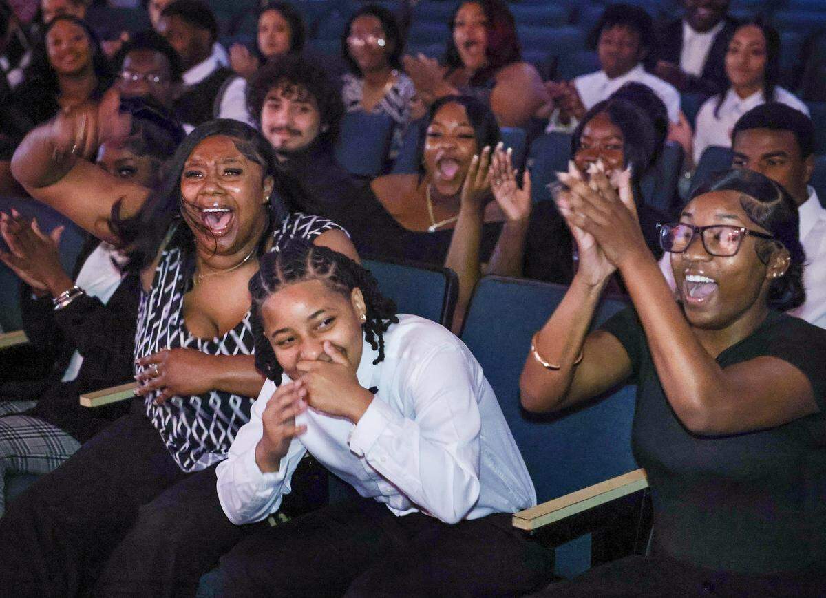 Yaz'Nique Jean Francois, center, reacts after being announced as the recipient of the Biscayne Bay Kiwanis Club full college scholarship as her friend Patricia Smith, left, and others cheer during the Booker T. Washington Senior High School Class of 2026 Senior Awards Ceremony, Tuesday, May 19, 2026, in Miami.