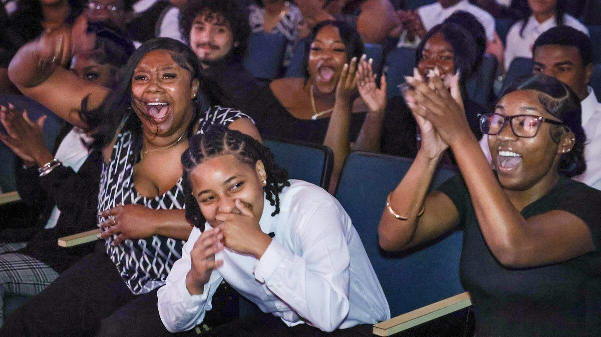Yaz’Nique Jean Francois, center, reacts after being announced as a recipient of a Biscayne Bay Kiwanis Club college scholarship as her friend Patricia Smith, left, and others cheer during the Booker T. Washington Senior High School Class of 2026 Senior Awards Ceremony, Tuesday, May 19, 2026, in Miami.