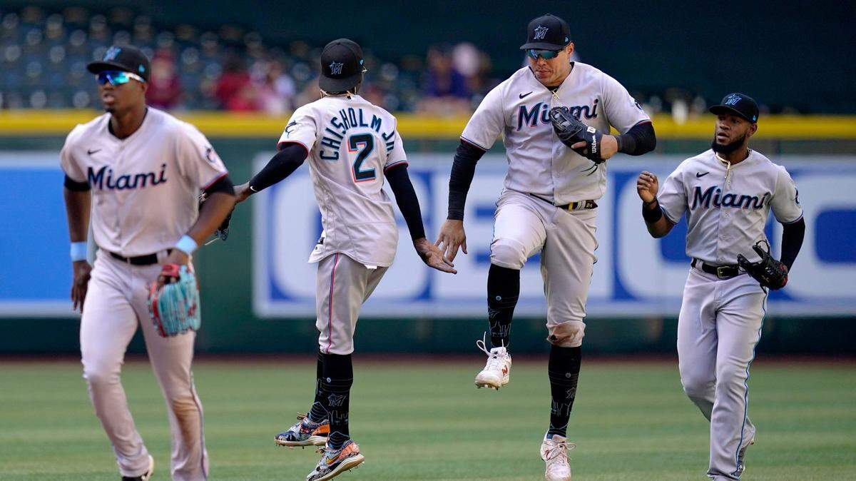Miami Marlins’ Jazz Chisholm Jr. (2) celebrates with Marlins’ Avisail Garcia, second from right, as they run off the field with Marlins’ Bryan De La Cruz, right, and Jesus Sanchez, left, after the final out of a baseball game against the Arizona Diamondbacks Wednesday, May 11, 2022, in Phoenix. The Marlins won 11-3.