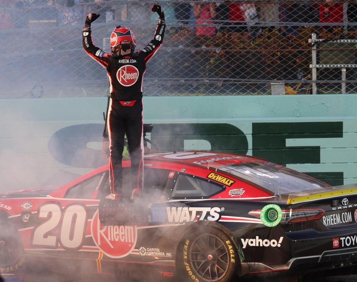 Christopher Bell stands on his car and lift his arms after winning the NASCAR 4EVER 400 Cup Series on Sunday, Oct. 22, 2023, at Homestead-Miami Speedway in Homestead, FL.