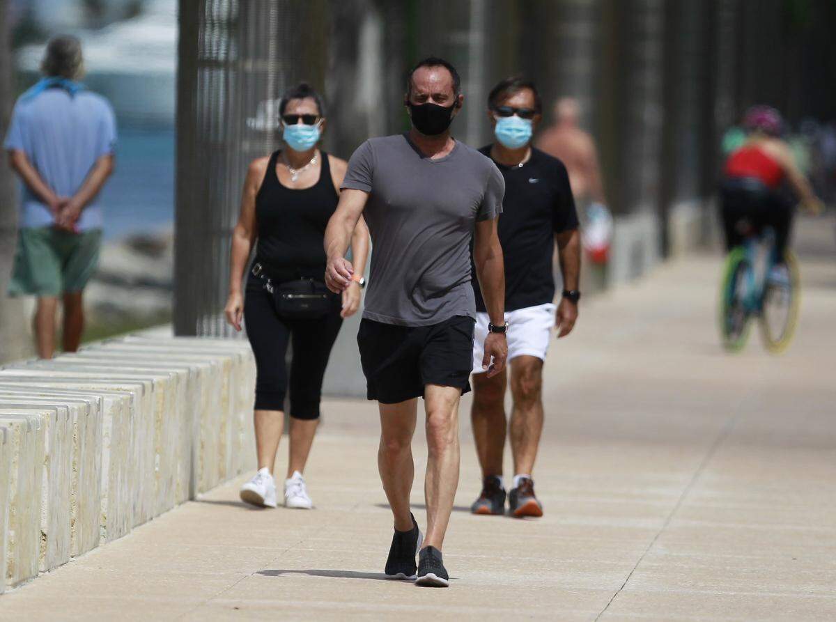 Park goers stroll down the promenade of South Pointe Pier as South Pointe Park reopened on Monday, May 11, 2020 after being closed last week due to park goers not following social distancing rules at the South Beach park.