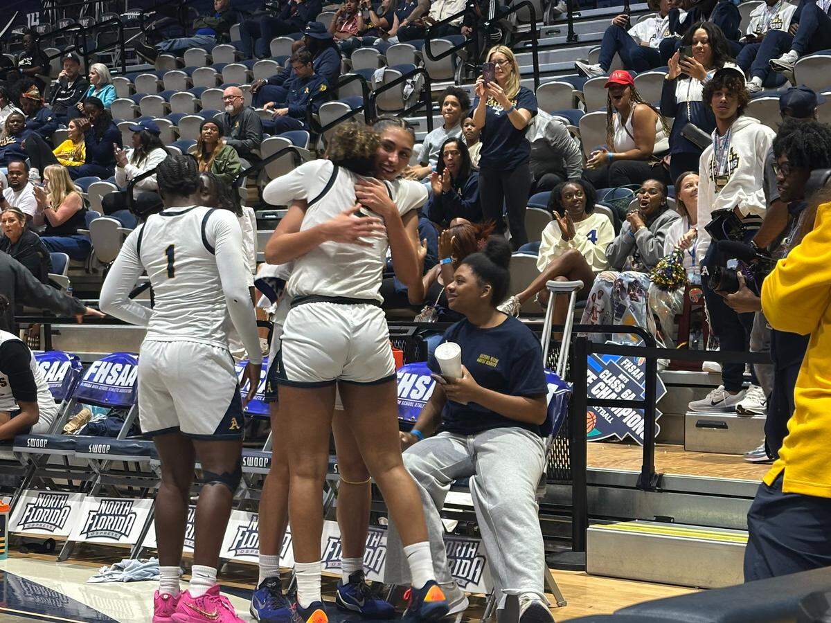 St. Thomas Aquinas’ Isabella Sangha and London Thomas share a hug as the final seconds tick away on their 65-22 victory over Palm Bay Bayside on Saturday in the Class 6A girls’ basketball state championship game at UNF Arena in Jacksonville, Fla.