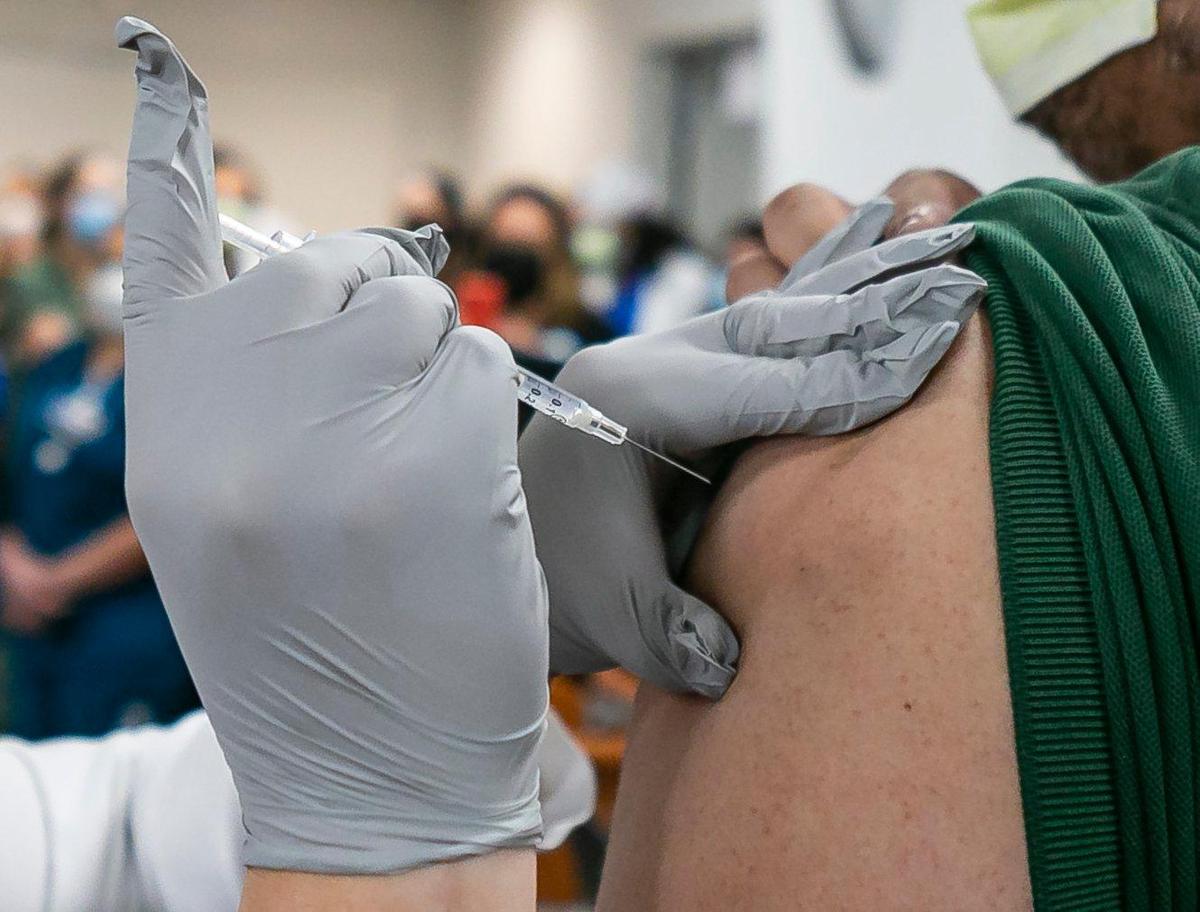 Environmental Service Worker Armando Acosta receives the Pfizer BioNTech COVID-19 Vaccine at Jackson Memorial Hospital in Miami, Florida on Tuesday, December 15, 2020.