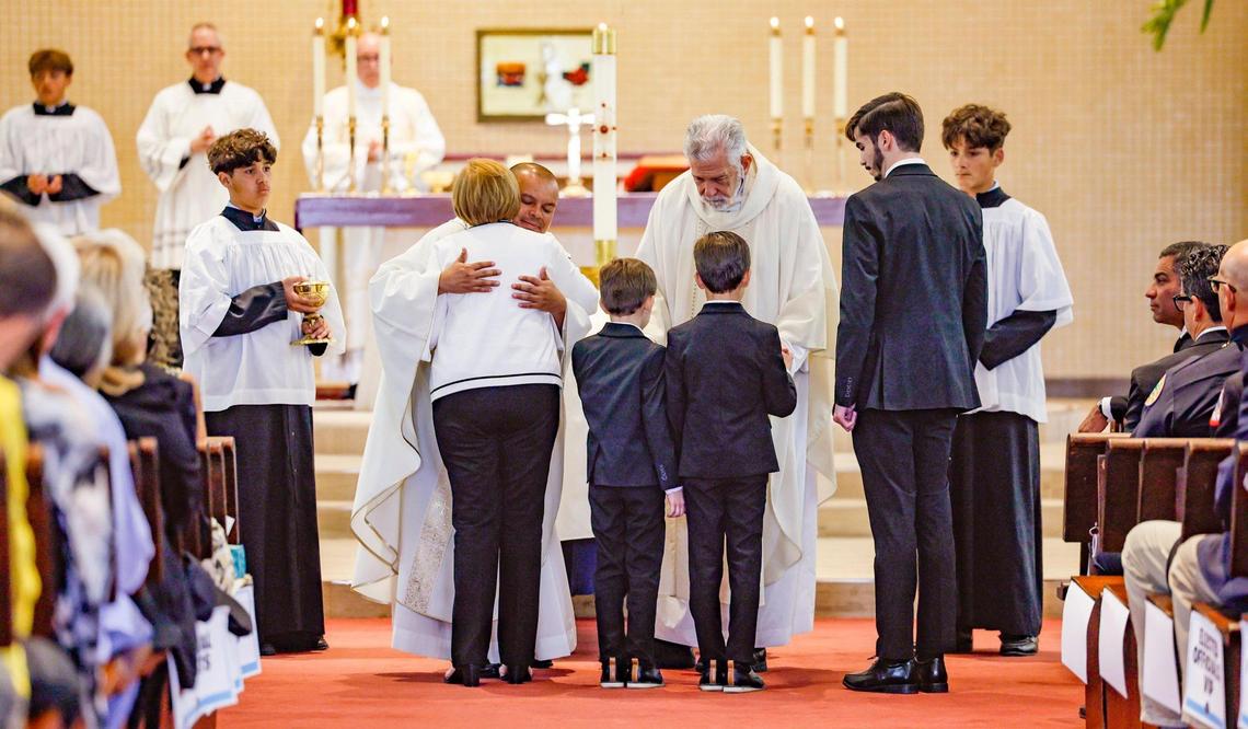 Father Elvis Gonzalez and Jose Luis Menendez greet the family of Miami City Commissioner Manolo Reyes during his funeral mass at St. Michael The Archangel Catholic Church in Miami, Florida on Wednesday, April 16, 2025.