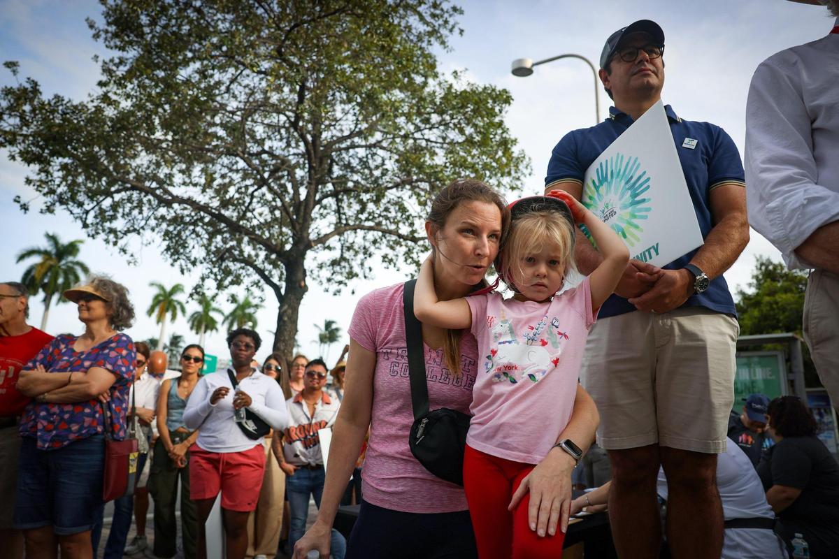 Jenny Carson, center, explains to her daughter, Maureen, 5, what an imam is at the We Are United march on Sunday, Nov. 5, 2023, at the Freedom Tower in Miami. “In the Islamic faith he’s like our pastor,” Carson explained.