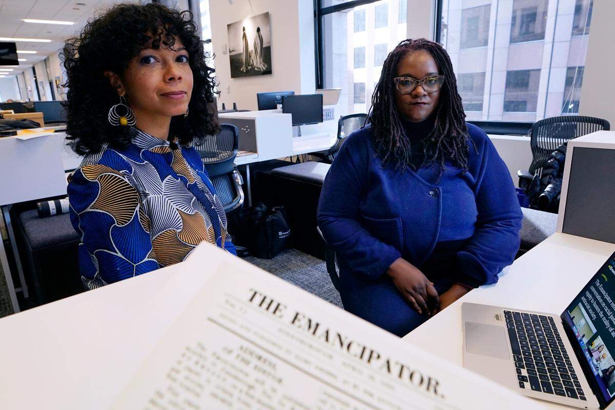 Amber Payne, left, and Deborah Douglas, co-editors-in-chief of the new online publication of “The Emancipator,” pose at their office inside the Boston Globe, Wednesday, Feb. 2, 2022, in Boston.