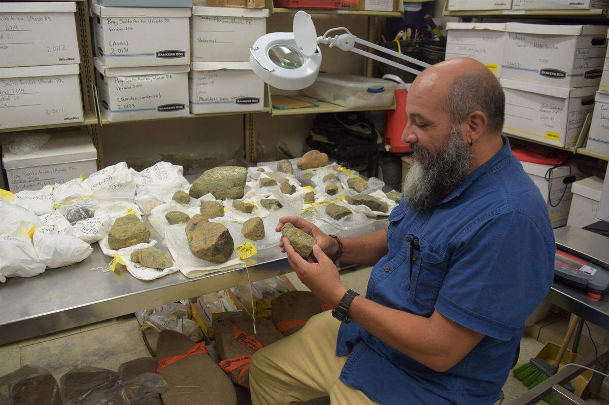 Reniel Rodríguez Ramos, arqueólogo de la Universidad de Puerto Rico en Utuado, sostiene una de las llamadas piedras del padre Nazario que ha estado estudiando.