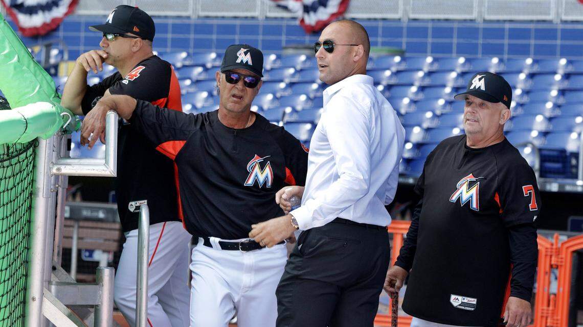 Miami Marlins CEO Derek Jeter (center), chats with Manager Don Mattingly and coach Perry Hill (far right), during a team stretch/workout a day before season opening’s work out day at Marlins Park on Wednesday, March 28, 2018.