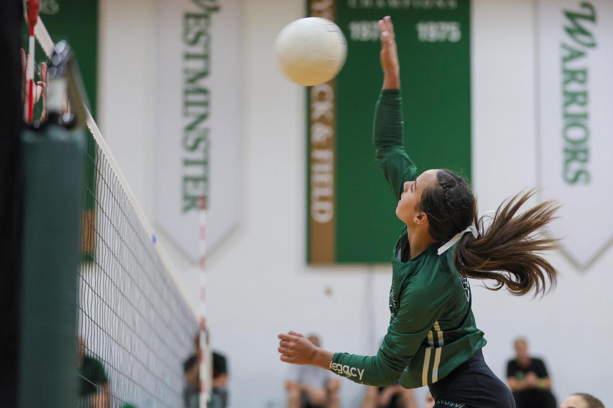 Westminster Christian Warriors libero Zoey Matias (12) jumps for a kill against the Palmer Trinity Falcons during the third set of a volleyball Region 4-3A quarterfinal playoff match at Westminster Christian School in Palmetto Bay, Florida, Tuesday, October 24, 2023.