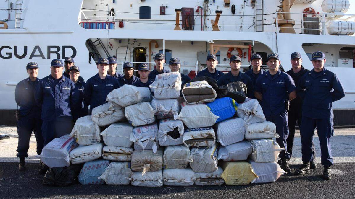 Coast Guard Cutter Resolute crew members stand next to approximately 1 ton of marijuana worth an estimated $2.2 million wholesale, in St. Petersburg, Florida, Tuesday, May 8, 2018. The crew aboard the 210-foot Reliance-class cutter, offloaded the drugs after interdicting two suspected drug smuggling vessels and detaining seven suspected smugglers.