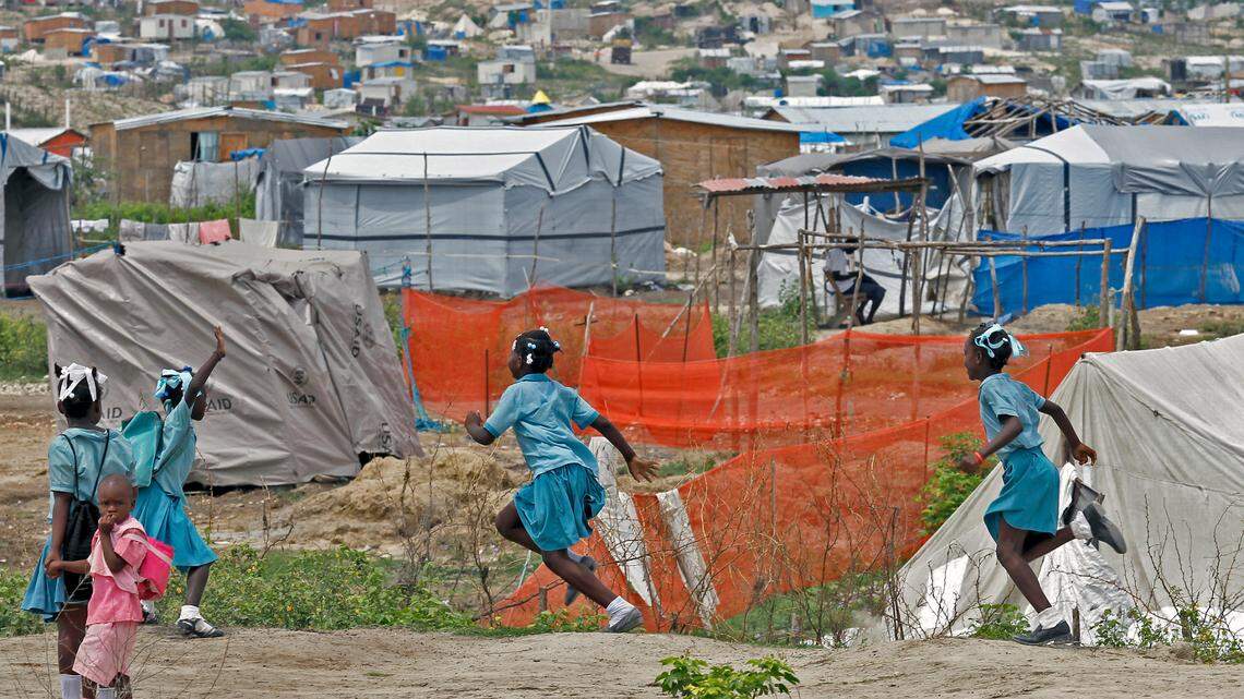 In this file photo, school children on Wednesday, May 11, 2011, walk a dirt path on their way home inside the Canaan1 camp where thousands of displaced earthquake survivors. Today in 2023, the settlement is controlled by a notorious gang warlord known as “Jeff.”