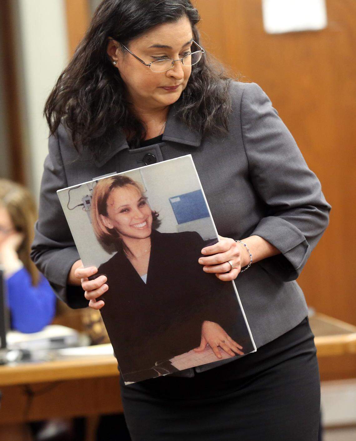 FILE - Prosecutor, Deisy Hernandez, holds a photograph of murdered waitress, Yvette Fariñas. Fariñas was murdered by Rafael Andres in 2005. The death penalty phase of Andres' trial was underway in Judge Dava Tunis' courtroom, Monday, Dec. 15, 2014.