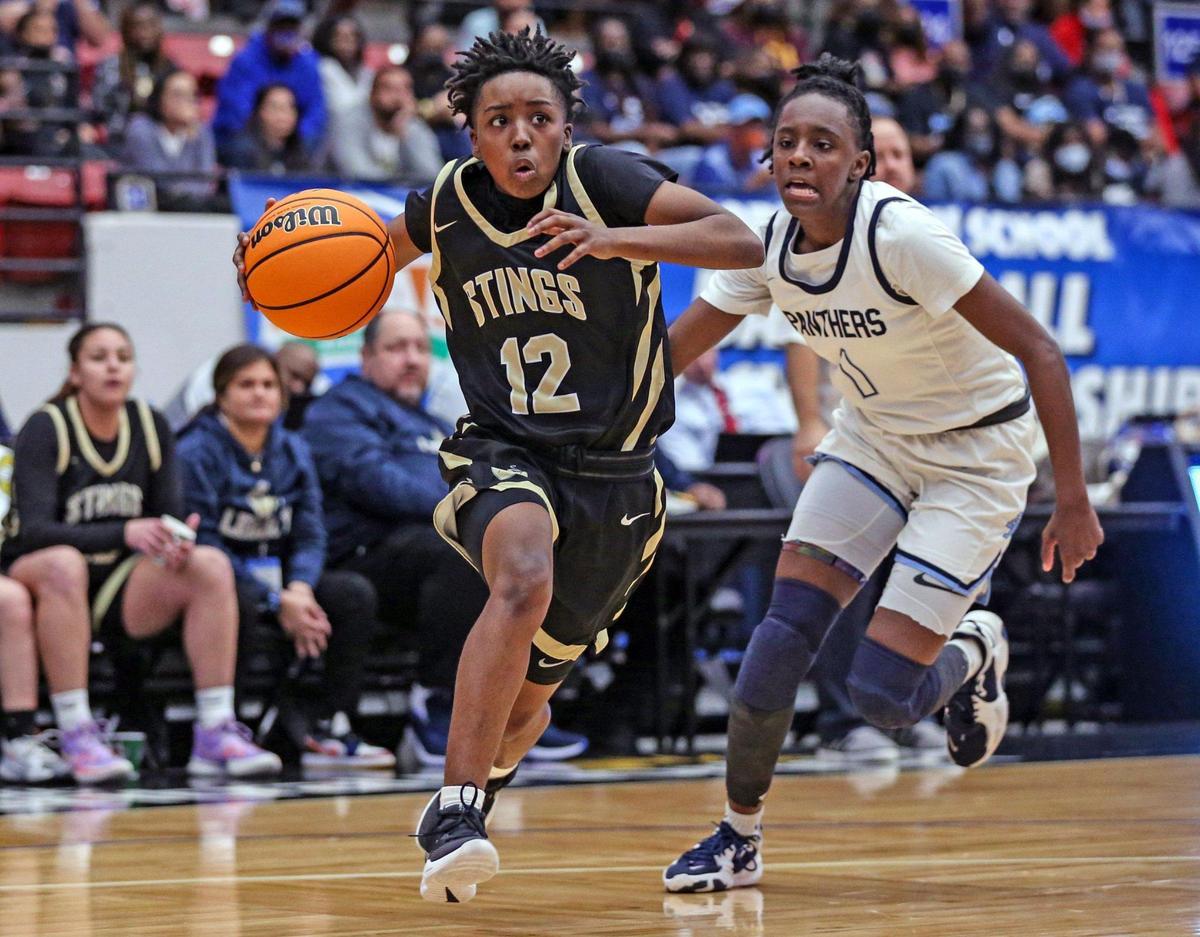Miami High’s Janay Quinn (12) drives to the basket as Dr. Phillips High School’s Kalea’ Rainey (1) defends in the Class 7A girls basketball state championship at the RP Funding Center in Lakeland on Saturday, February 26, 2022.