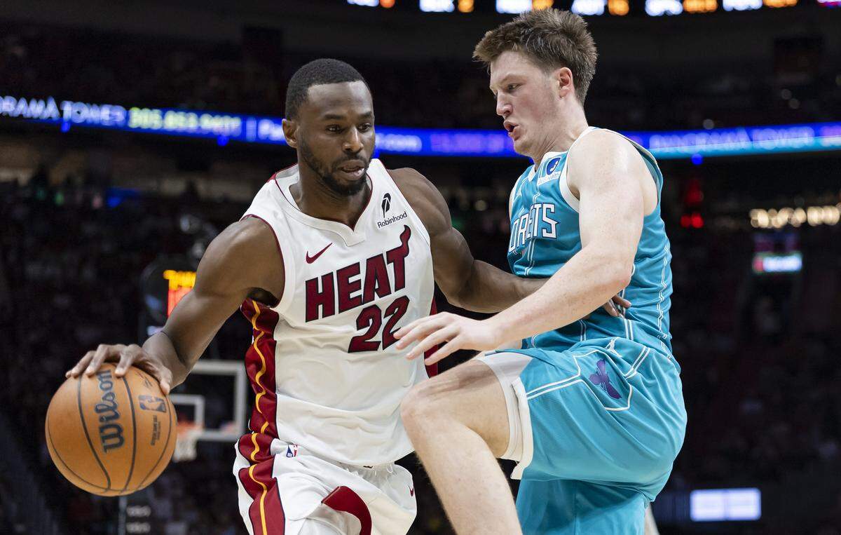 Miami Heat forward Andrew Wiggins (22) drives the ball as Charlotte Hornets guard Kon Knueppel (7) defends in the second half of their NBA game at Kaseya Center on Oct. 28, 2025, in Miami.