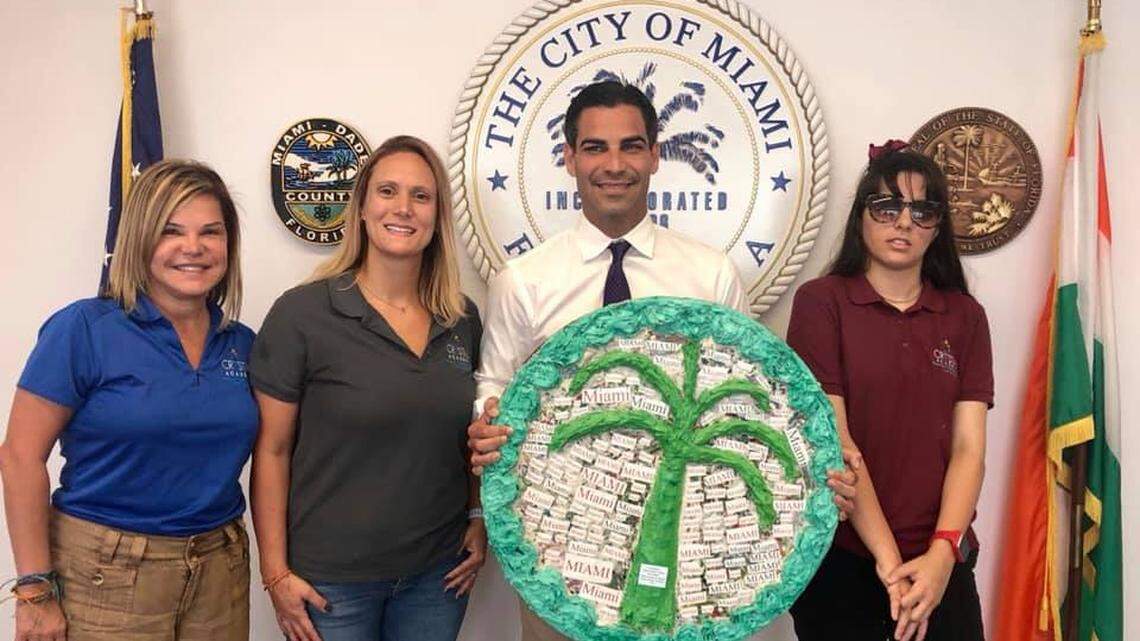 Maridith Imbasala Castro, diagnosed with Autism Spectrum Disorder, made this mixed media crest with her occupational therapist and art teacher at Crystal Academy. The artwork hangs in the office of City of Miami Mayor Francis X. Suarez. From left, Mary Palacio-Pike, founder of Crystal Academy; Jill Flores-Belardi, occupational therapist and art teacher; City of Miami Mayor Francis X. Suarez; and Maridith Imbasala Castro.