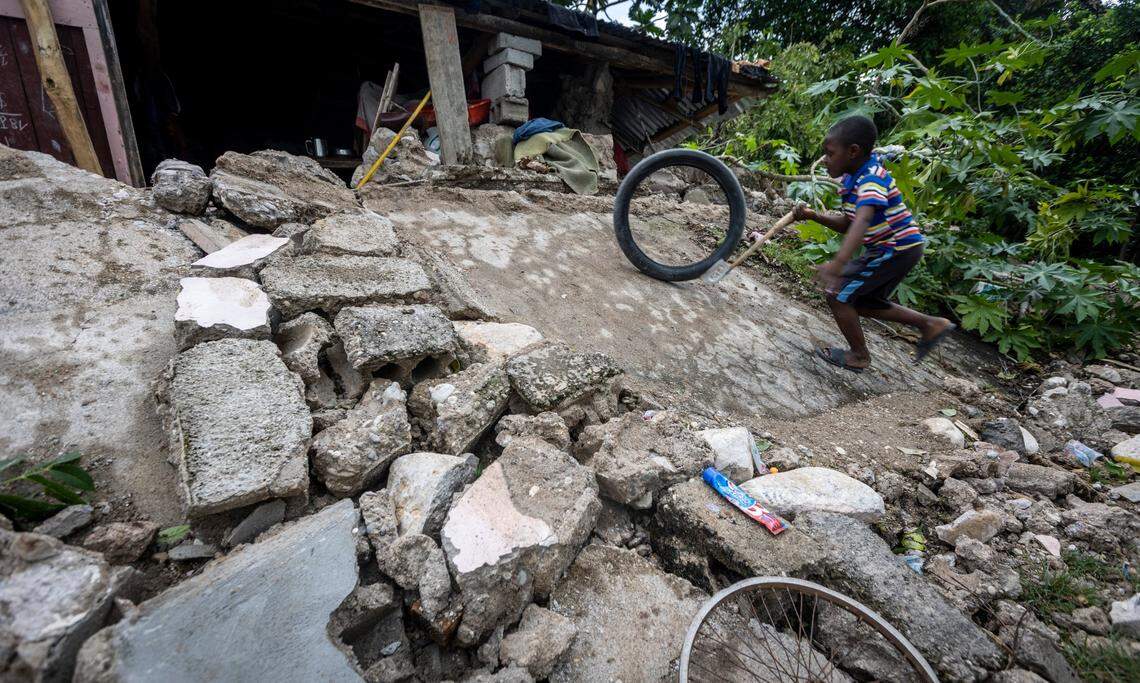 Isaac Cadet, 6, plays in front of a collapsed house that is still being used as a shelter in Marceline, Haiti, on Aug. 18, 2021. Isaac was trapped in the rubble for 5 hours after the house collapsed; he was rescued by his family.