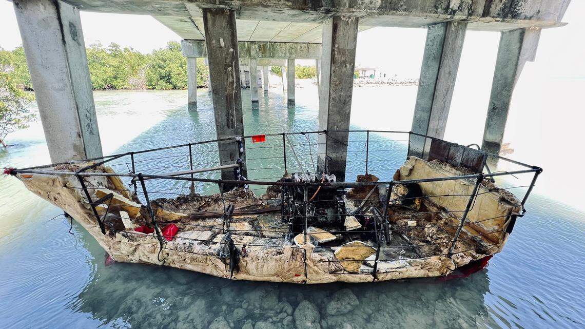 A migrant boat floats in shallow water under a bridge in Sugarloaf Key Friday, April 1, 2022.
