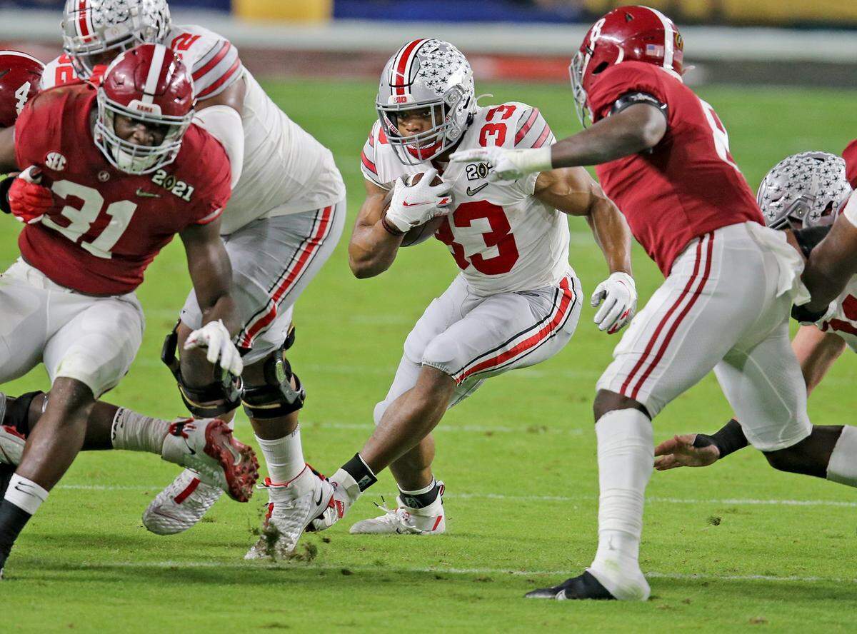 Ohio State Buckeyes Master Teague (33) runs the ball in the third quarter as they play the Alabama Crimson Tide in the 2021 College Playoffs National Championship at Hard Rock Stadium in Miami Gardens, Florida, Monday, January 11, 2021.