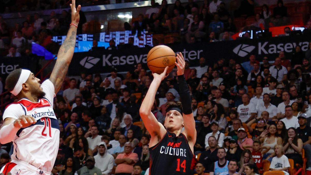 El guardia del Miami Heat, Tyler Herro (14), encesta un triple mientras el pívot de los Washington Wizards, Daniel Gafford (21), defiende en la segunda mitad en el Kaseya Center de Miami el viernes 3 de noviembre de 2023.