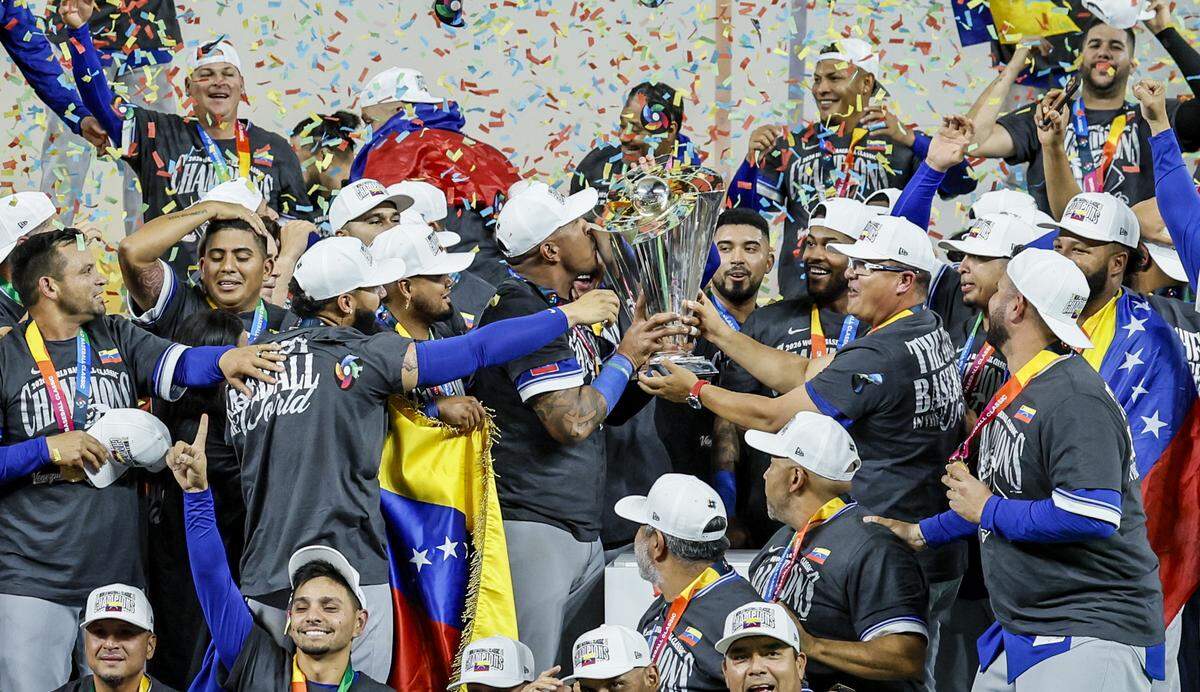 Venezuela players celebrate with the championship trophy after defeating the United States during the final game of the 2026 World Baseball Classic at loanDepot park on Tuesday, March 17, 2026. 