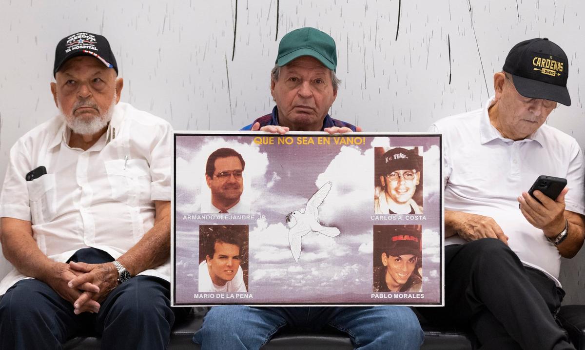 Nelson Morales, center, the brother of the late Pablo Morales, a pilot who was shot down in international waters by Cuban Air Force MIG jet fighters, holds a sign before the start of a press conference at the American Museum of the Cuban Diaspora on Tuesday, Sept. 24, 2024, in Miami, Fla. Members of the Florida Bar called on local and state authorities to indict retired Cuban colonel Luis Raúl González-Pardo, who is residing in the United States, for his alleged role in the 1996 shoot-down of two civilian planes over the Florida Straits that killed four Miamians.