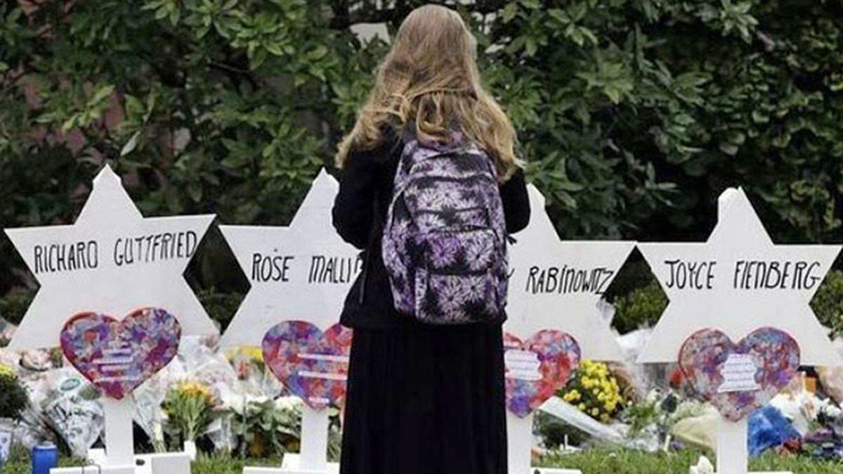 A woman stands before a memorial that honors the 11 people killed in a shooting at a Pittsburgh synagogue in October 2018.
