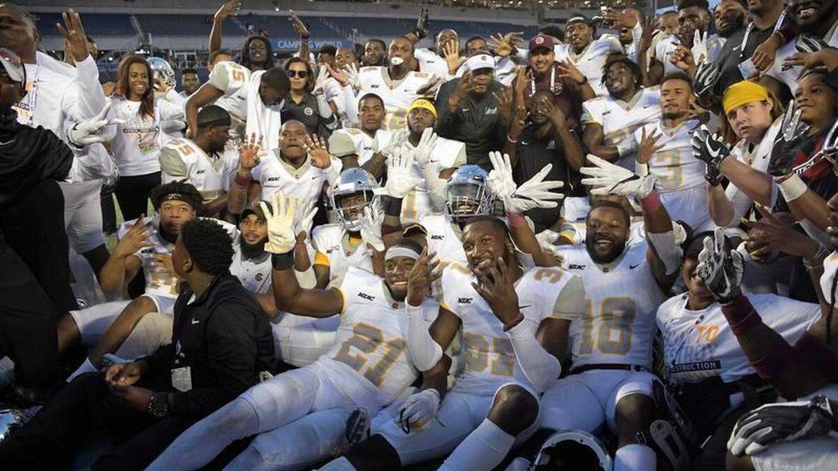 Bethune-Cookman head coach Terry Sims, center, poses with his players after getting a 33-19 win over Florida A&M during the Florida Classic NCAA college football game Saturday, Nov. 17, 2018, in Orlando, Fla.
