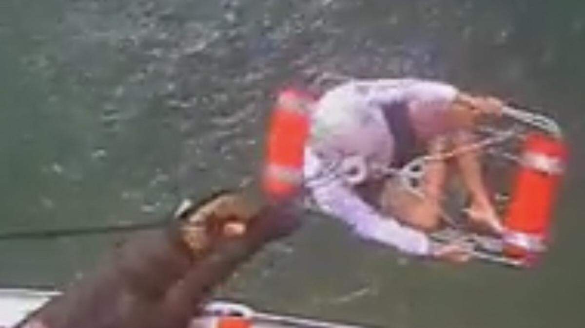 A crew member of a U.S. Coast Guard MH-65 Dolphin helicopter hoists a man to safety after his kayak capsized off Key Largo Tuesday, April 20, 2021.