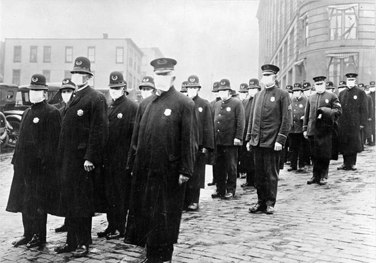 Seattle police officers in December 1918 wear masks from the Red Cross.