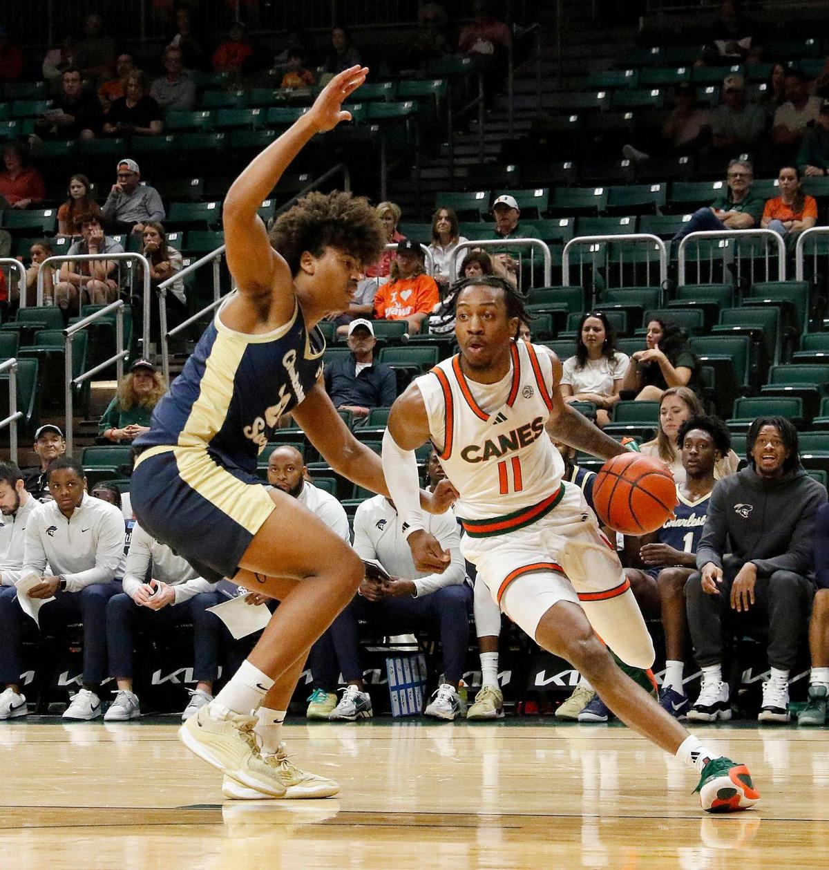 UM Hurricanes AJ Staton-McCray (11) slides around Charleston Southern University Buccaneers Reis Jones (23) during the basketball game on Saturday, November 30, 2024 at Watsco Center in Coral Gables. Andrew Uloza / for Miami Herald