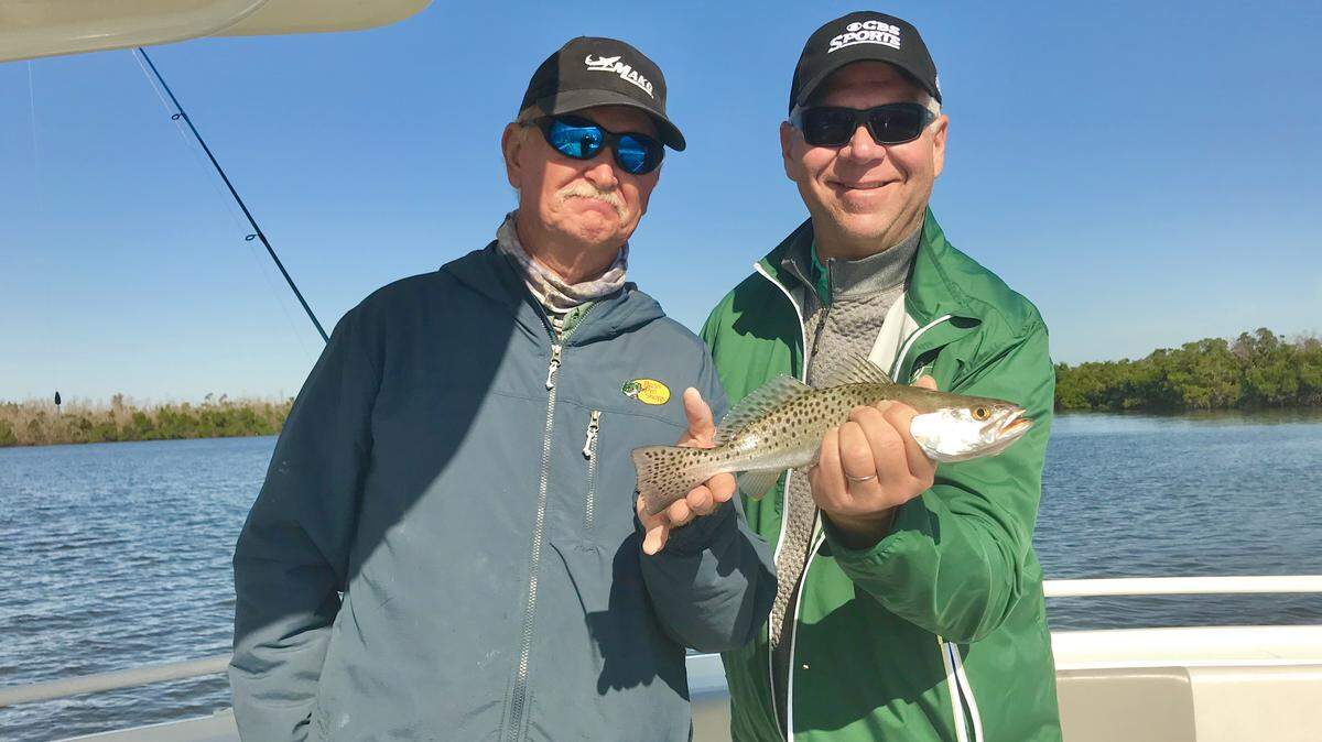 George McNeilly holds a sea trout that he caught and released fishing with a live shrimp in the 10,000 Islands out of Goodland with Capt. Kevin Bellington, left, of Sea Gone Fishing.