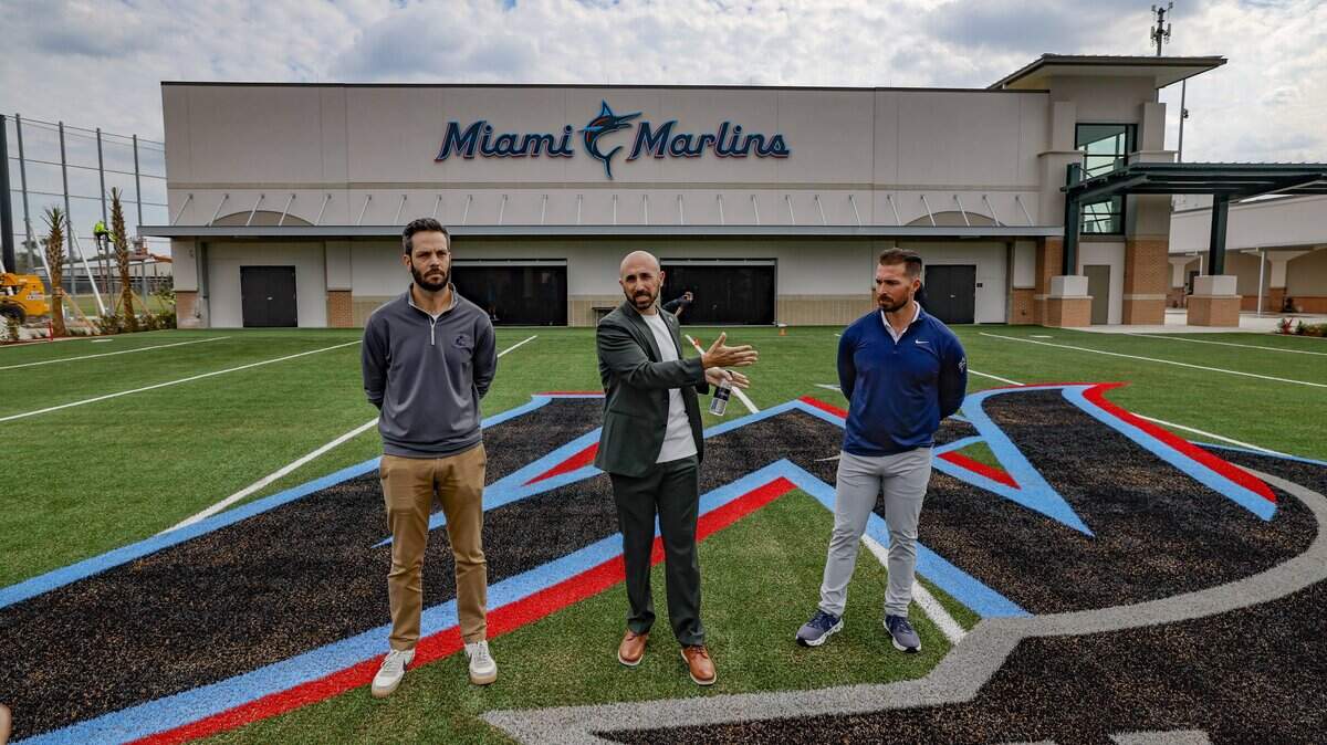 Marlins chief brand officer Alex Parker, Marlins senior vice president of facilities, projects and corporate services Tony Brasile, and Marlins director of clubhouse operations Simon Beloff, standing left to right, give the media a tour of Marlins Jupiter Academy during the first day of Miami Marlins spring training at Roger Dean Chevrolet Stadium in Jupiter, Florida on Wednesday, February 11, 2026