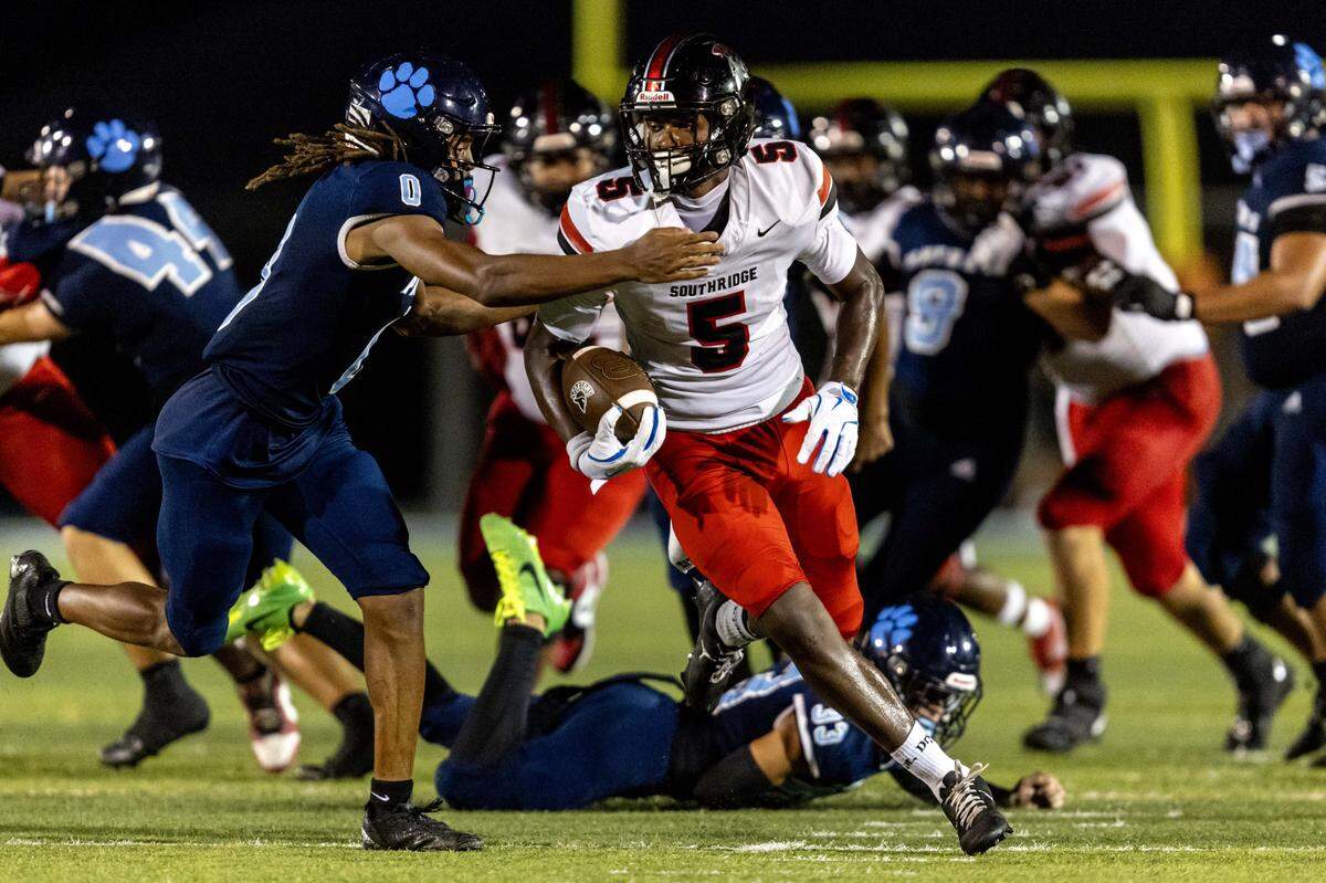 Spartans running back Varian Terry (5) runs past Panthers defensive back Kevin White (0) as he carries the ball during the first half of a high school football game between Palmetto and Miami Southridge at Tropical Park on Thursday, September 4, 2025, in Miami, Fla.