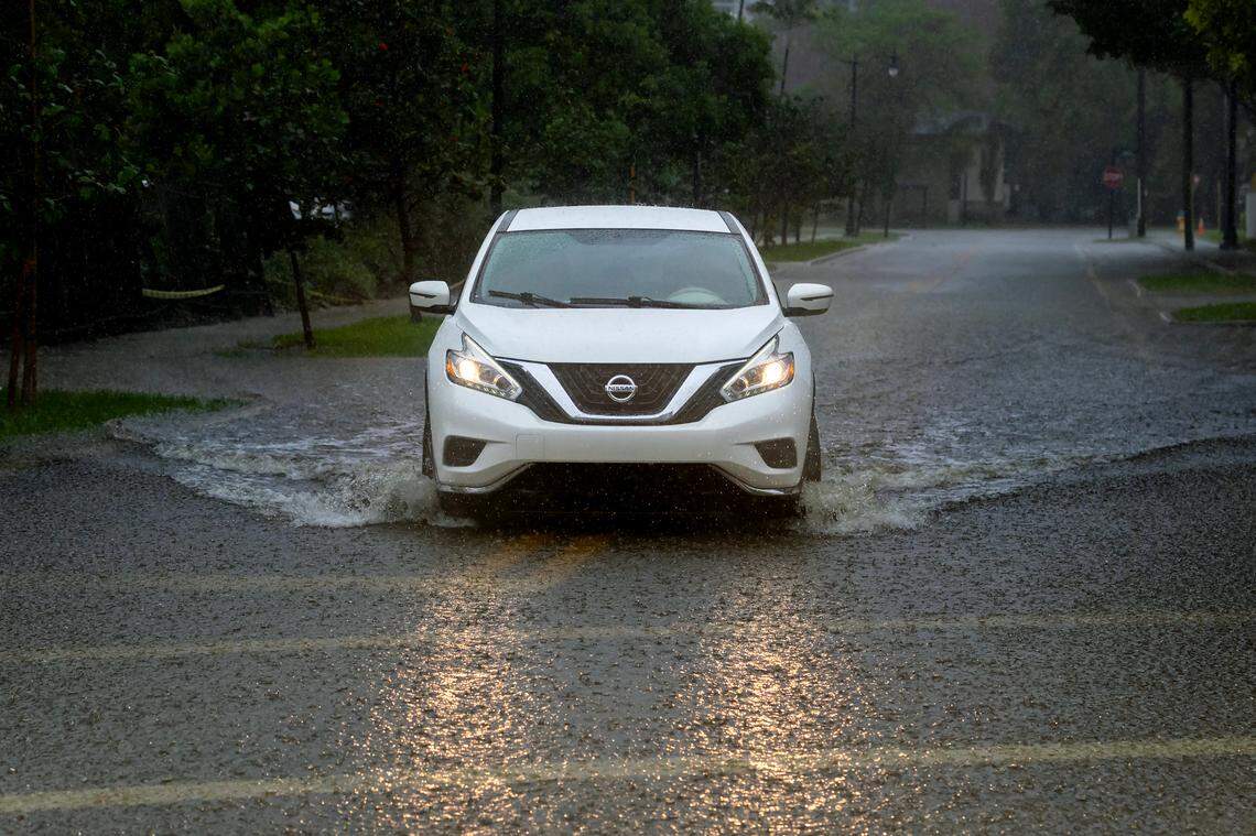 A car crosses the flooded road caused by heavy rain on North Bay Rd and 179th Dr. in Sunny Isles Beach on Tuesday, June 11, 2024 in Florida.