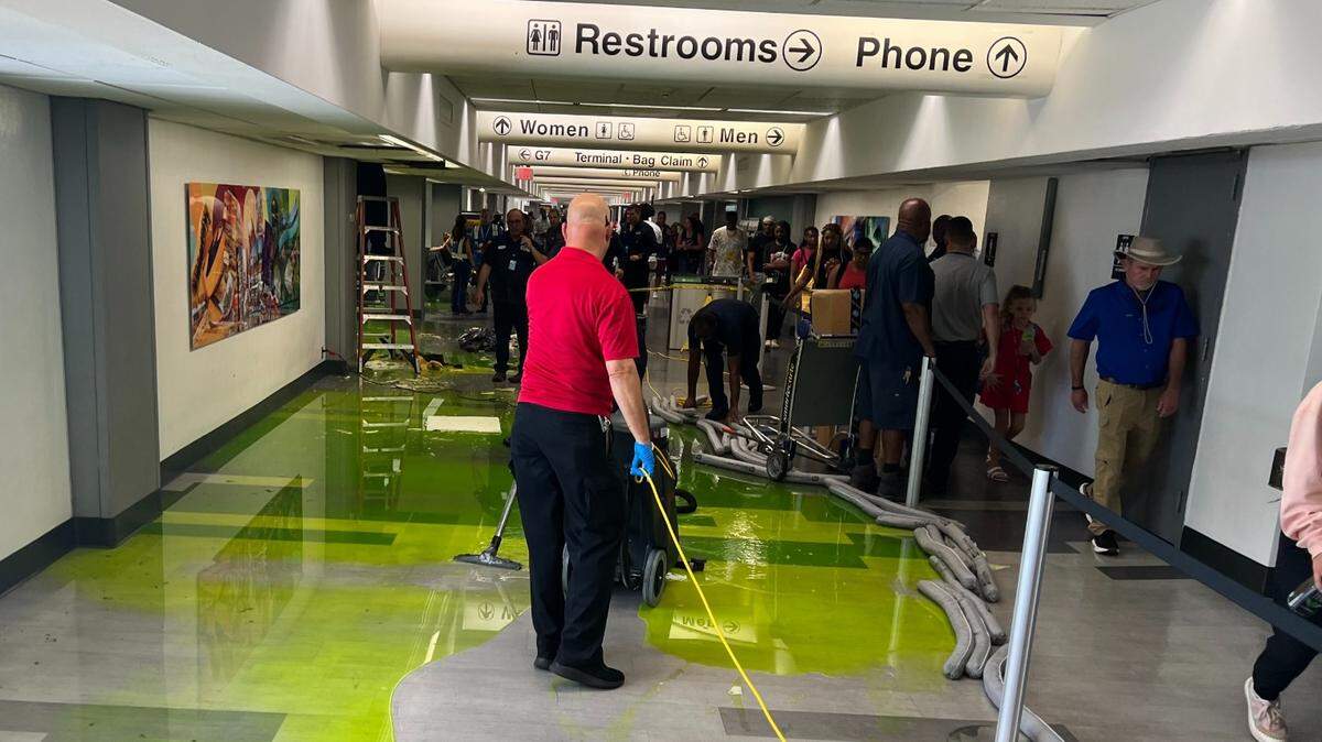 The cleanup of green water on Miami International Airport’s Concourse G the morning of July 4, 2024.