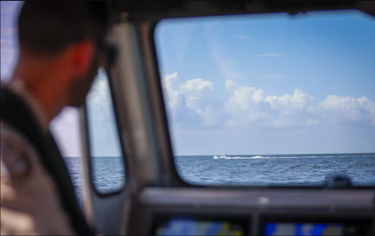 Florida Fish and Wildlife Conservation Commission Capt. Matthew DallaRosa pilots a boat as a boater passes by during a tour in Old Tampa Bay in May.