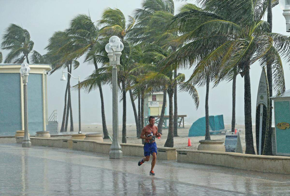 A beachgoer runs under the rain at the Hollywood Beach Broadwalk on Saturday, August 31, 2019 at Hollywood Beach in Florida. As of the 11 a.m. advisory, Hurricane Dorian is a category 4 storm.