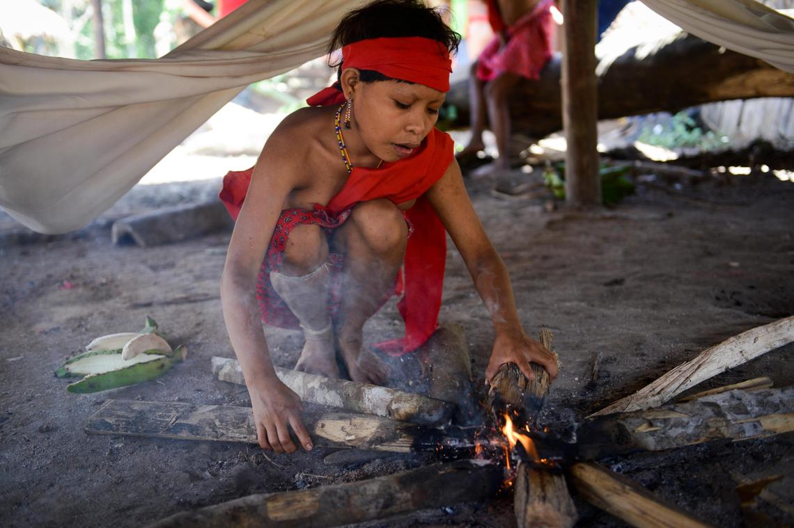 A Yanomami native woman kindles the fire in her dwelling at the Irotatheri community, Amazonas state, southern Venezuela. Violence generated by the mining of gold has endangered indigenous people, leading to such incidents as the slaughter of 80 Yanomami natives in 2012, apparently by rogue prospectors.
