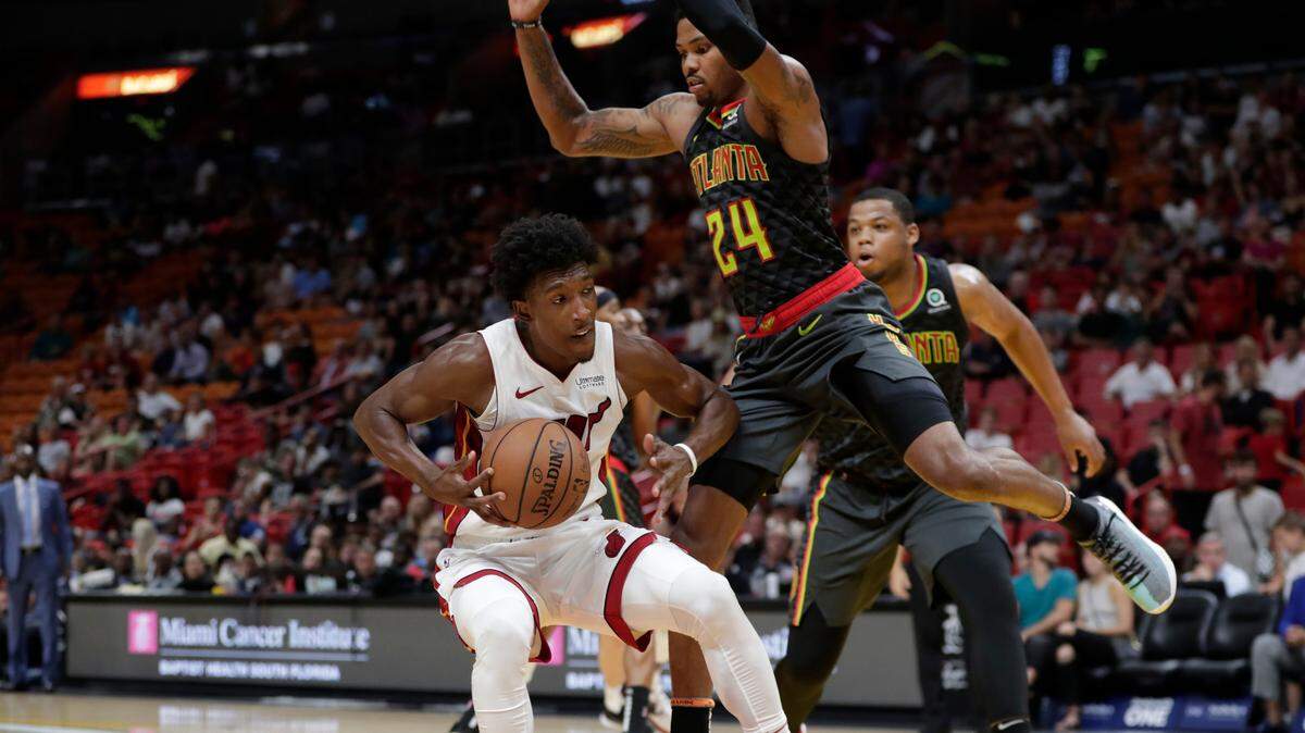 Josh Richardson, del Heat (izq.), trata de sacarse la marcación de Kent Bazemore, de los Hawks (24), este viernes en Miami.